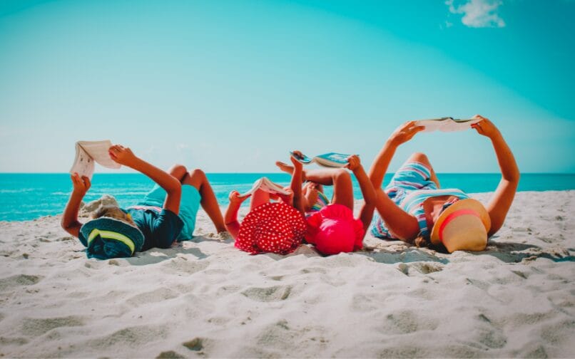 Una familia leyendo en la playa.