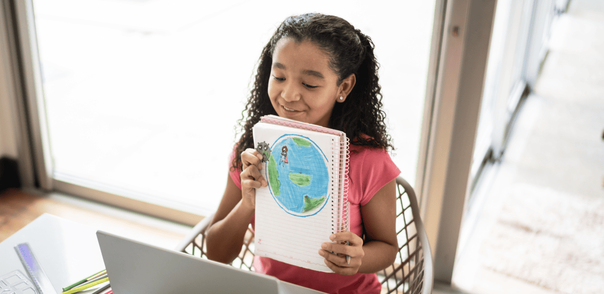 Una niña sostiene un cuaderno con el diseño de un globo terráqueo, símbolo de la exploración y el conocimiento.